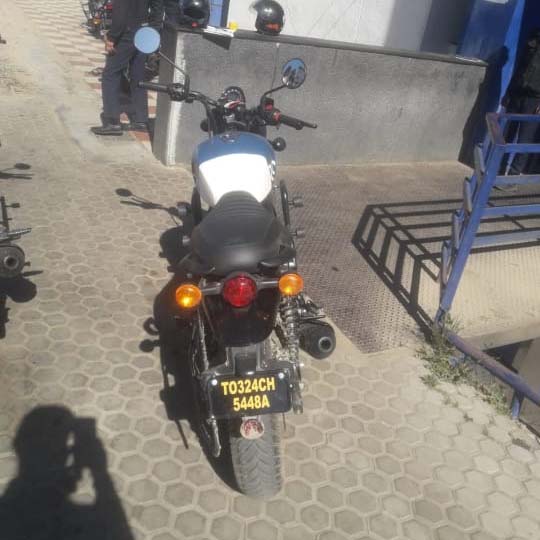 Rear view of a blue and white Royal Enfield Hunter 350 motorcycle, license plate T0324CH 5448A.